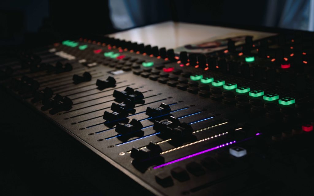 Audio mixing board with colorful buttons and faders
